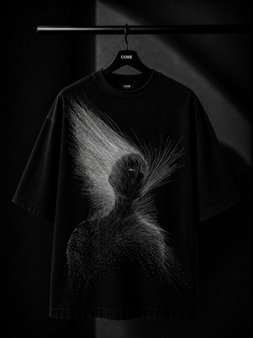 Black oversized T-shirt featuring a minimalist white abstract line-art graphic on the back, displayed on a premium wooden hanger in a dark luxury studio setting.