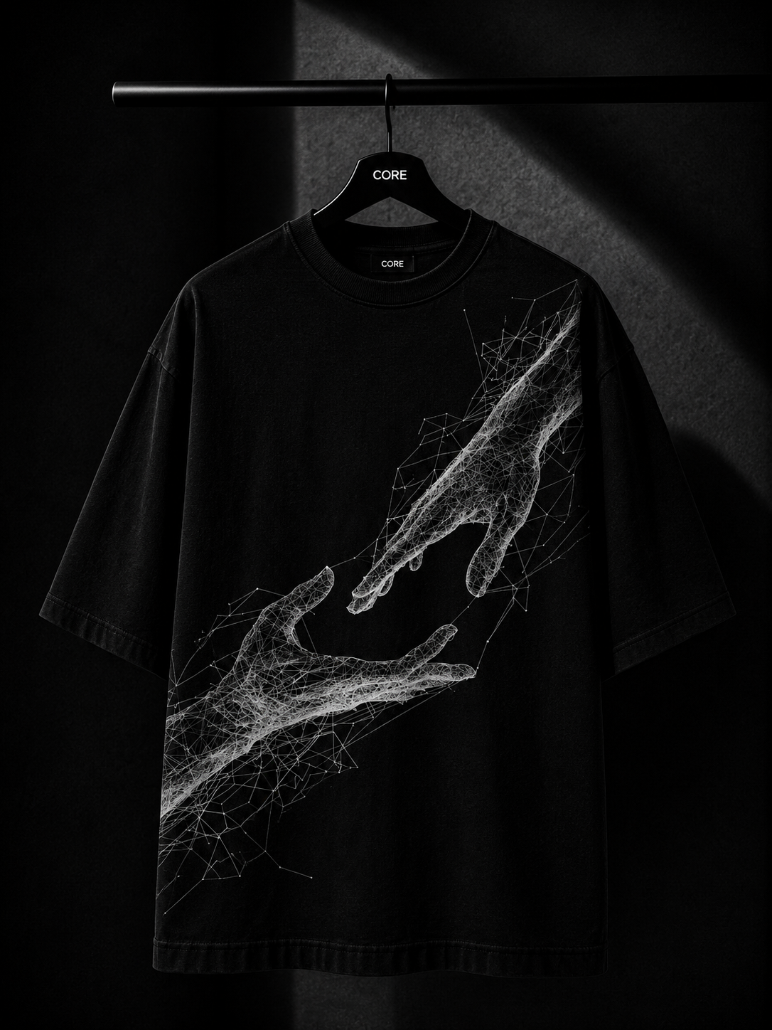Black oversized T-shirt featuring a white abstract wireframe graphic of two hands reaching toward each other, displayed on a premium wooden hanger in a dark luxury studio setting.