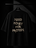 Black oversized T-shirt with a bold "Need Money For Protein" back print in a distressed typography design, displayed on a premium studio hanger.