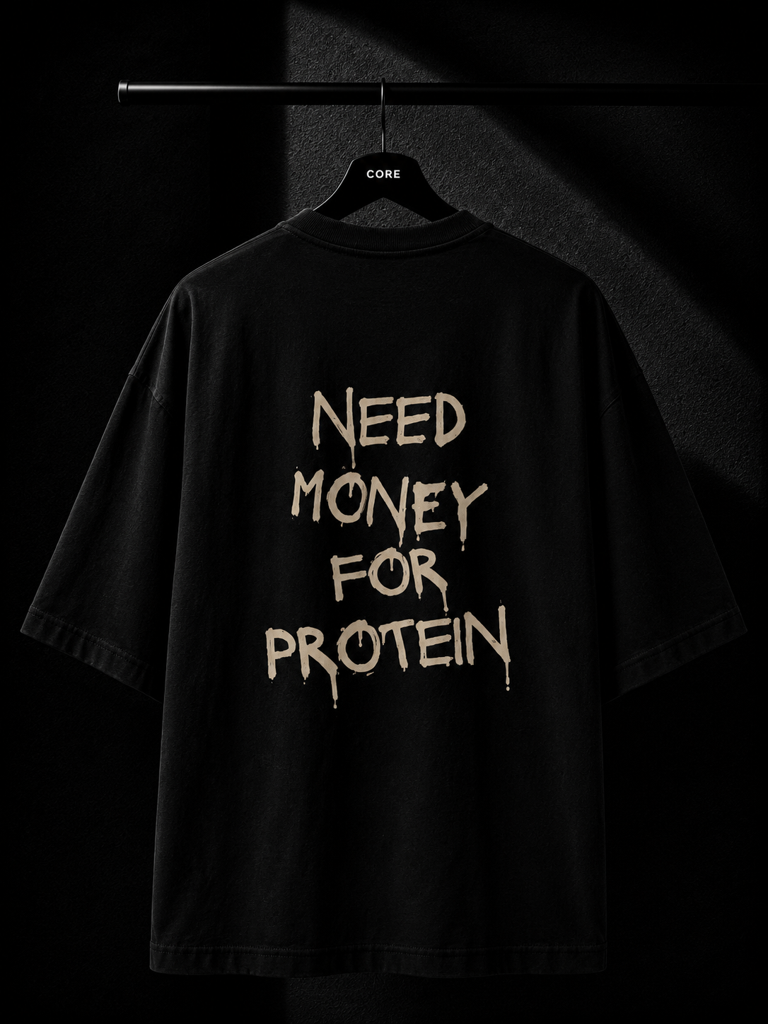 Black oversized T-shirt with a bold "Need Money For Protein" back print in a distressed typography design, displayed on a premium studio hanger.