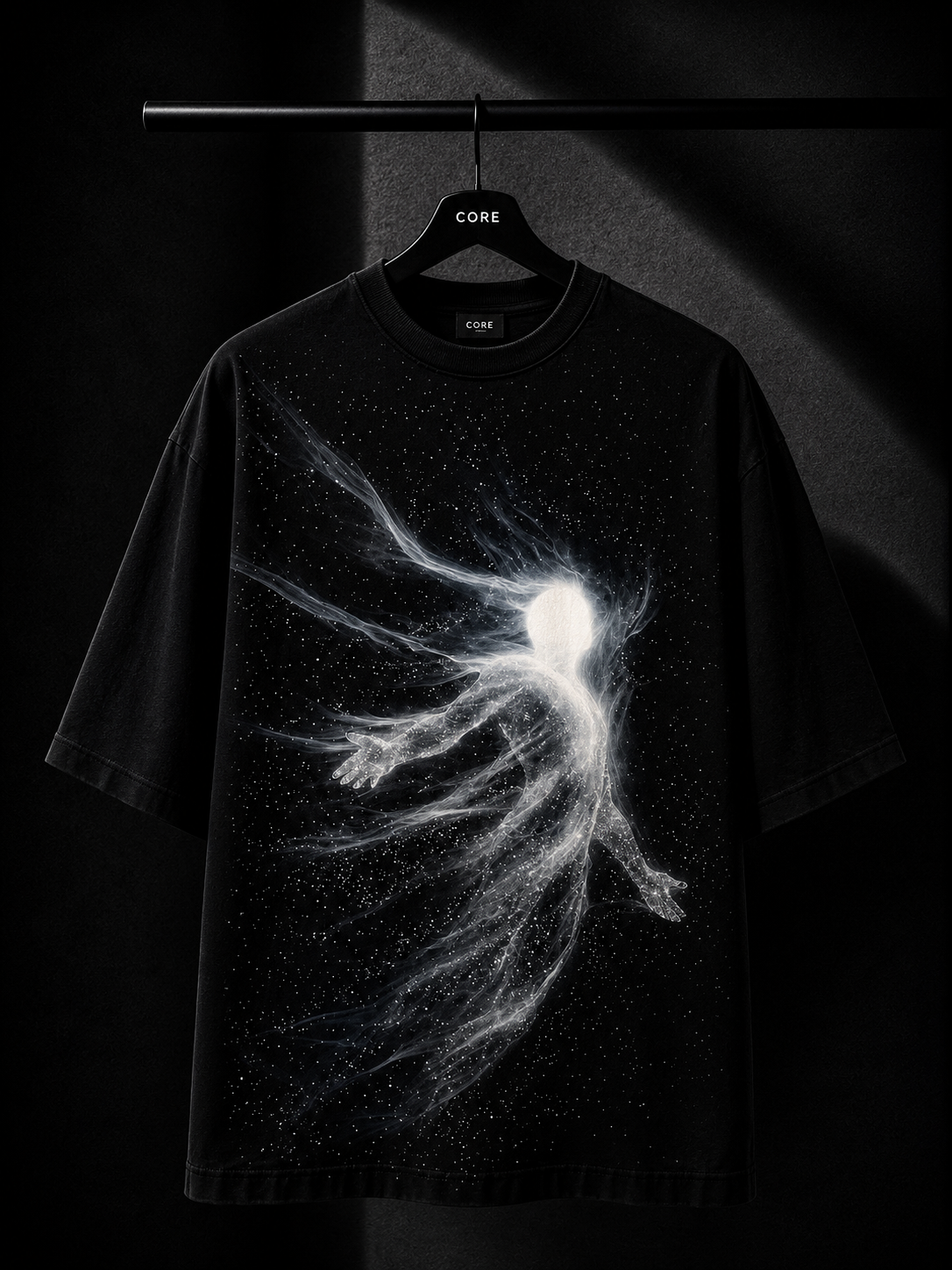 Black oversized T-shirt with a minimalist white cascading leaf graphic across the right shoulder, hanging on a premium wooden hanger in a luxury dark studio setting.