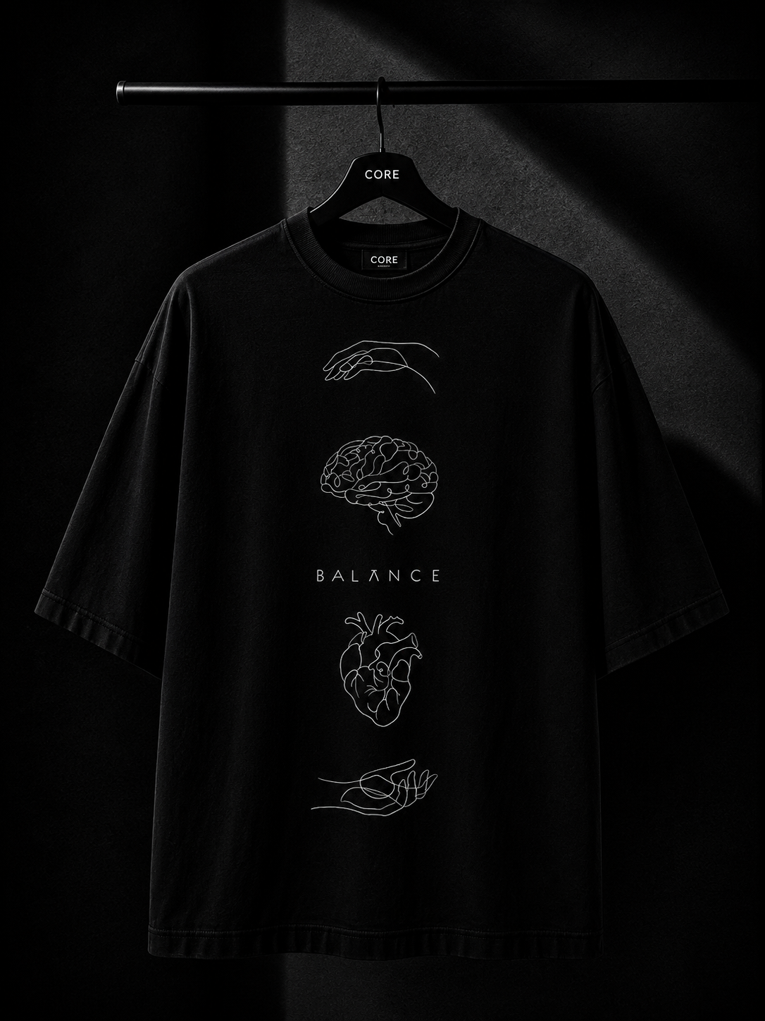 Black oversized T-shirt featuring a minimalist white leaf graphic cascading from the right shoulder onto the chest, displayed on a wooden hanger in a premium dark studio setting.
