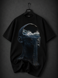 Black oversized graphic T-shirt featuring a hooded faceless figure with glowing molten orange energy flowing through the face and chest, framed by a fiery halo on a premium black fabric.